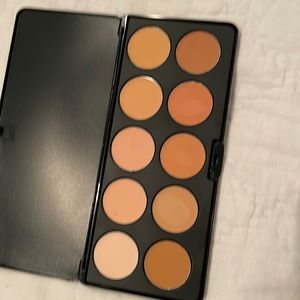 Lot of make-up art supplies including : concealer and foundation palettes…